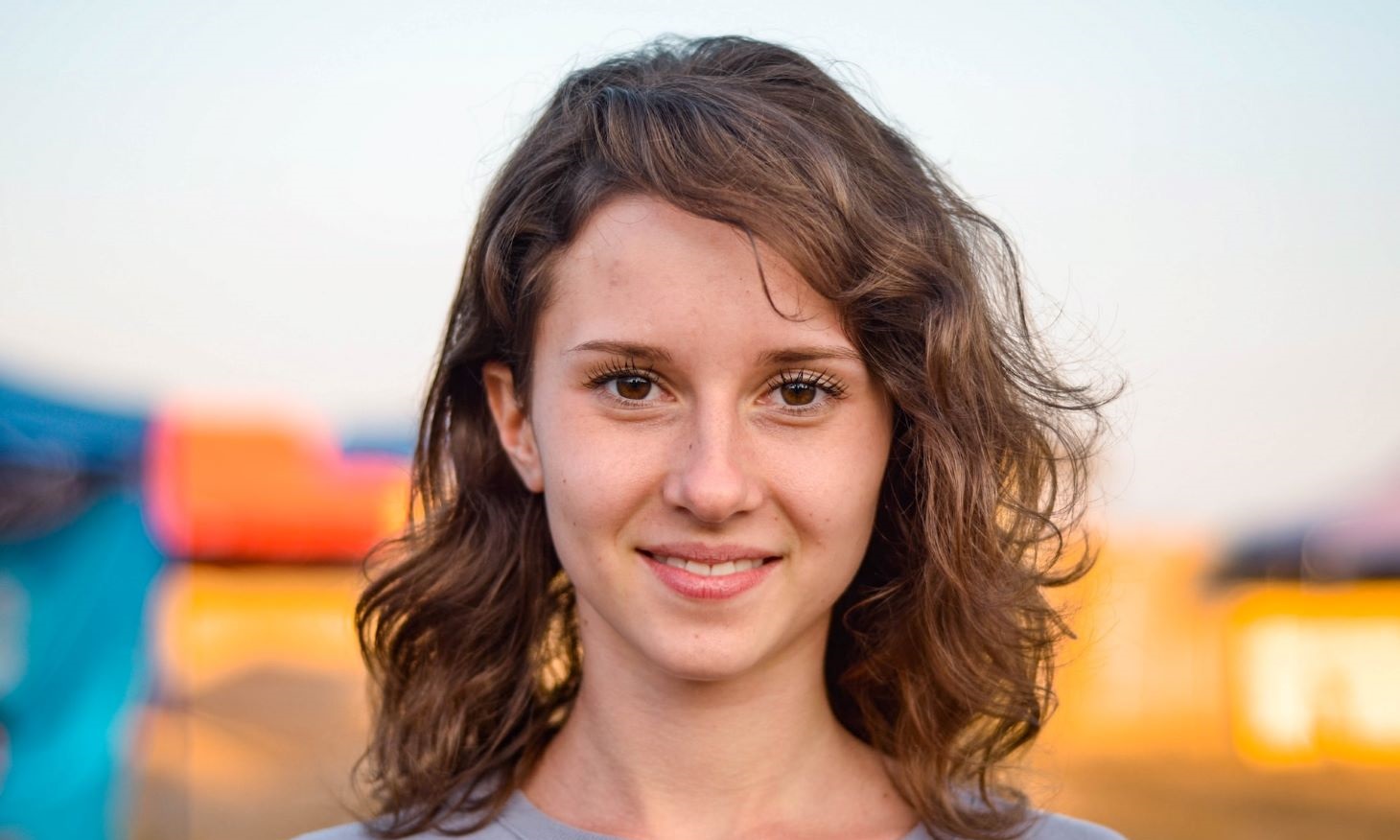 woman with curly hair and a smile that shows teeth