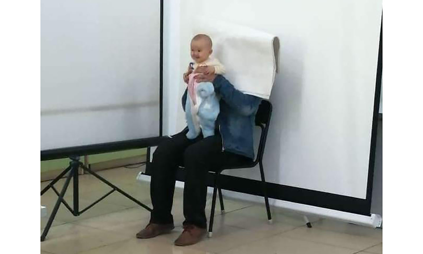 person sitting and holding a baby in their arms during a passport photography session