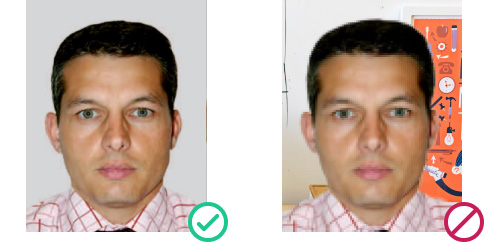 UK passport photo example: plain light background accepted vs. cluttered indoor background rejected 